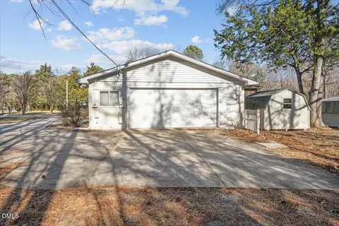 a view of large trees with backyard of house