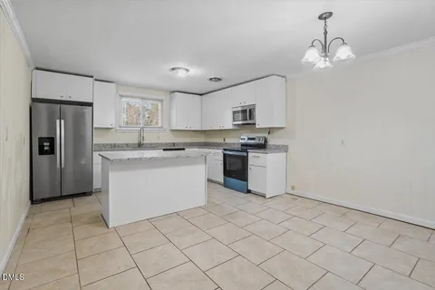 a kitchen with stainless steel appliances granite countertop a sink a stove a refrigerator and cabinets