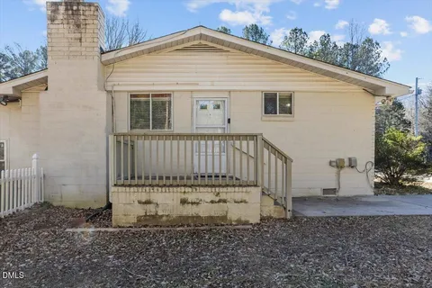 a view of a house with backyard and a tree