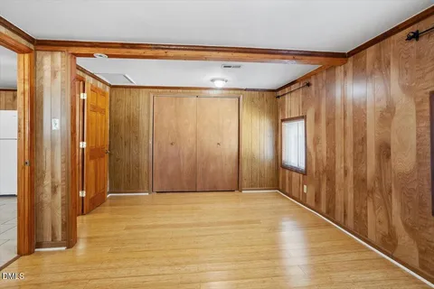 a view of an empty room with wooden floor