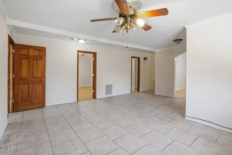 a view of a livingroom with a chandelier fan and windows