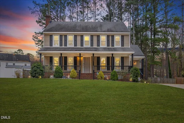 a front view of a house with a yard and potted plants