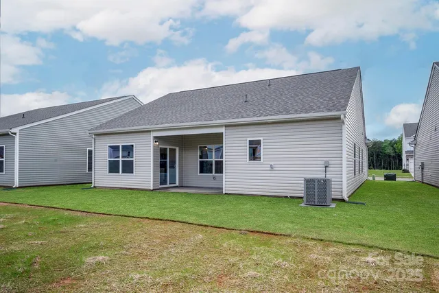 a view of a house with a yard and large tree