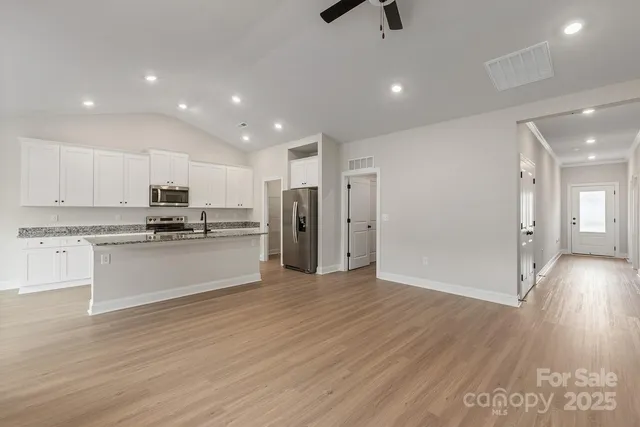 a kitchen with stainless steel appliances granite countertop a refrigerator and a stove top oven