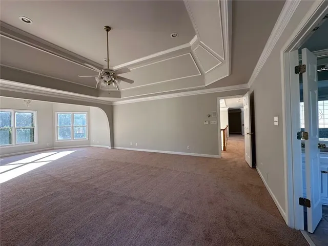 a view of a room with a ceiling fan and window