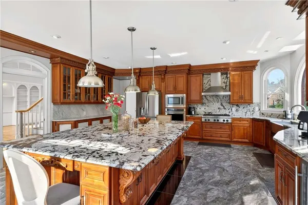 a view of a kitchen with stainless steel appliances granite countertop a stove a sink and a refrigerator