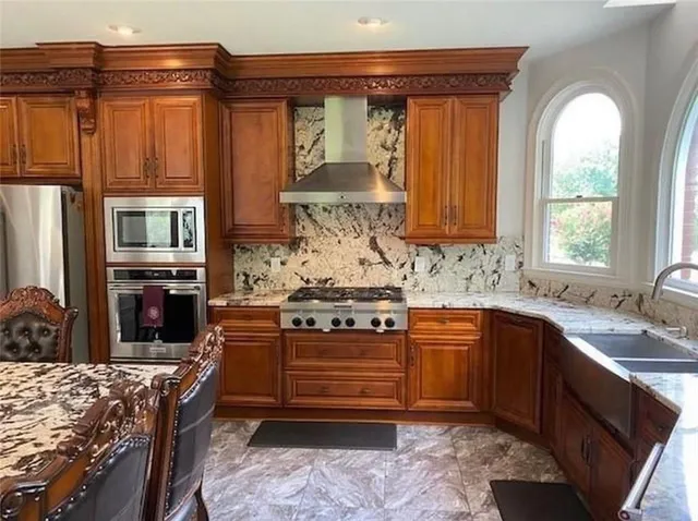 a kitchen with stainless steel appliances granite countertop a sink and wooden cabinets
