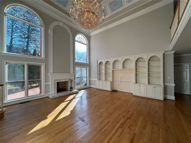 a view of empty room with wooden floor and fireplace
