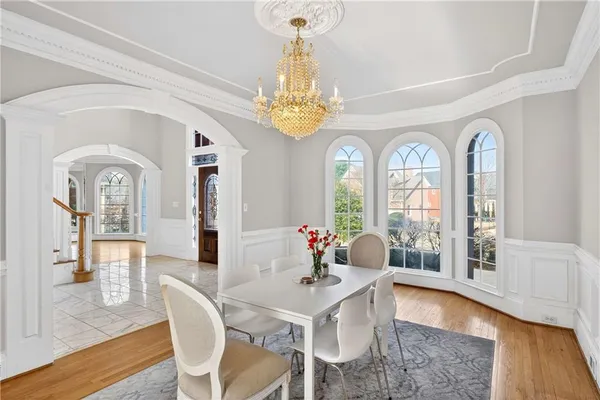 a view of a dining room with furniture a chandelier and wooden floor