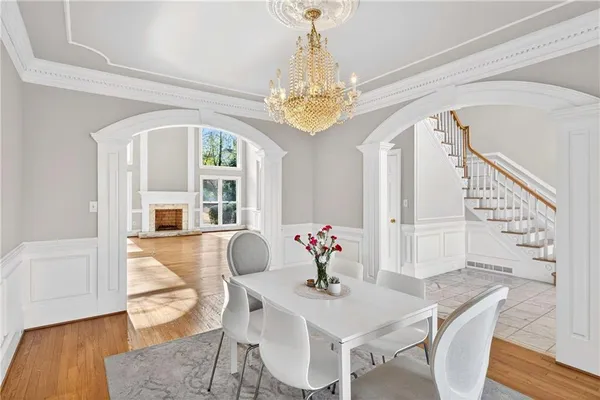 a view of an empty room with wooden floor fireplace and a window