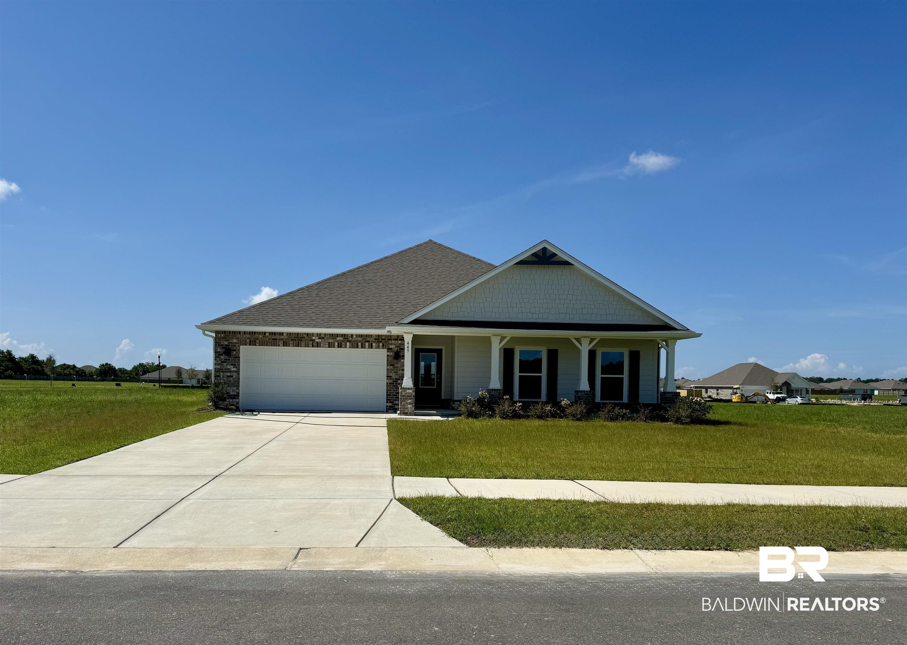 445 Raley Farms Drive Gulf Shores, AL 36542 - Photo 1 of 30 Craftsman house with a front yard, an attached garage, concrete driveway, and stone siding
