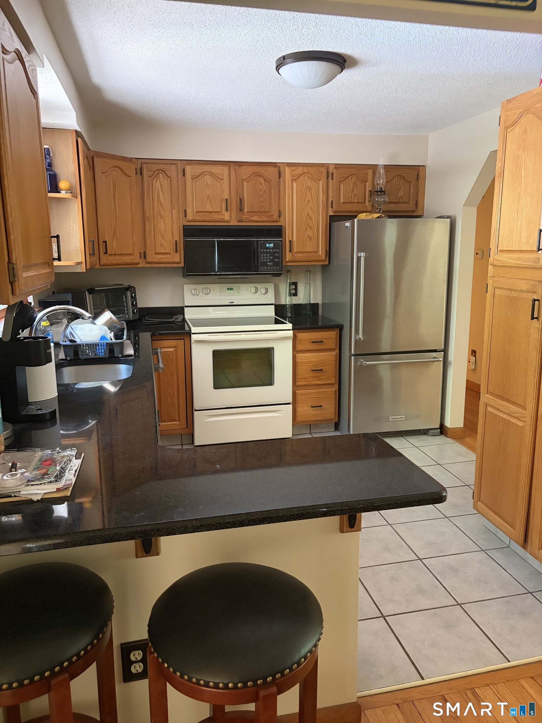 109 Village Hill Road Willington, CT 06279 - Photo 14 of 22 a kitchen with stainless steel appliances granite countertop a stove a sink dishwasher a refrigerator a microwave oven with granite countertops and cabinets