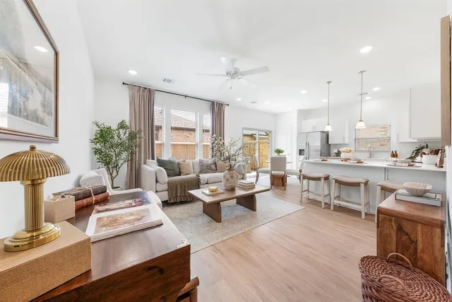 a living room with furniture kitchen view and a wooden floor