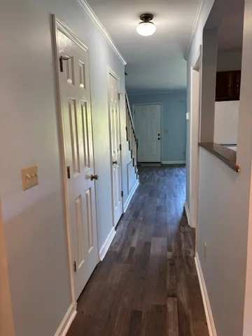 a view of a hallway with wooden floor and staircase