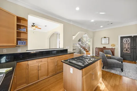 a kitchen with granite countertop a stove and white cabinets