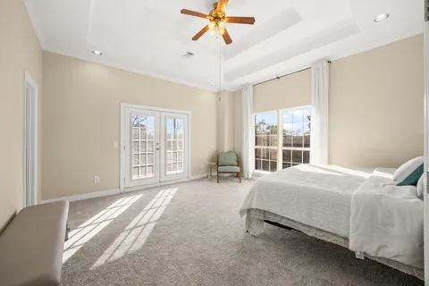 a spacious bedroom with a bed and a chandelier