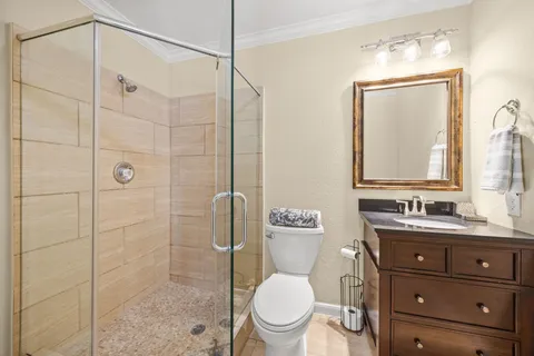 a bathroom with a toilet sink vanity and shower