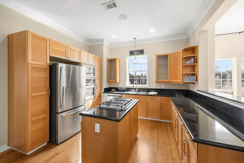 a kitchen with stainless steel appliances granite countertop a refrigerator stove and sink