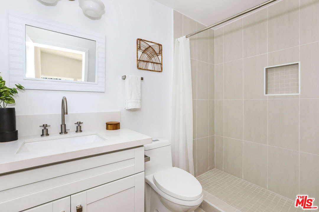 3922 Roderick Road Los Angeles, CA 90065 - Photo 12 of 29 a bathroom with a toilet a sink and mirror