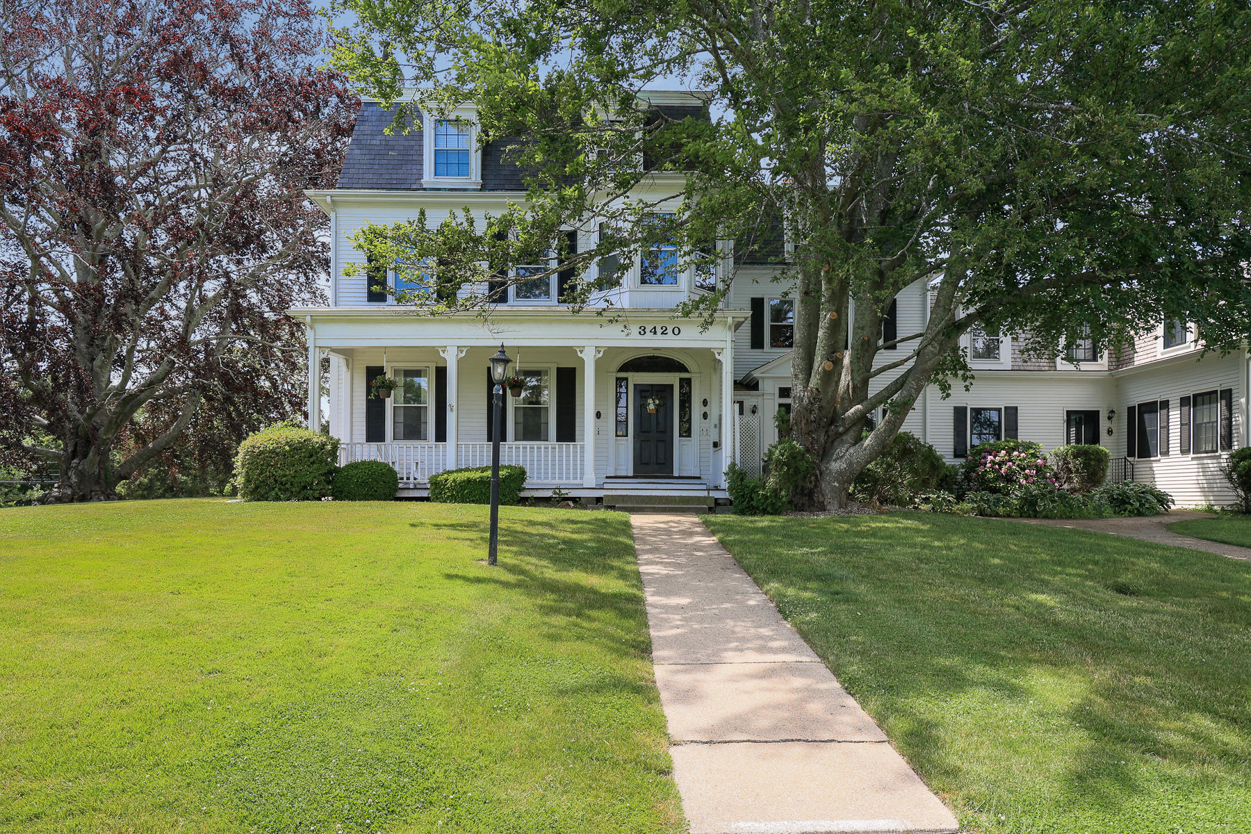 3420 Main Street, Unit 3 Barnstable, MA 02630 - Photo 3 of 28 a view of house in front of a big yard with large trees and plants