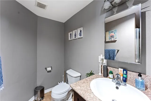 a bathroom with a sink mirror vanity and toilet