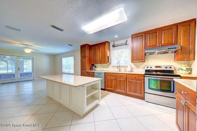 a kitchen with stainless steel appliances granite countertop a stove top oven a sink dishwasher and cabinets