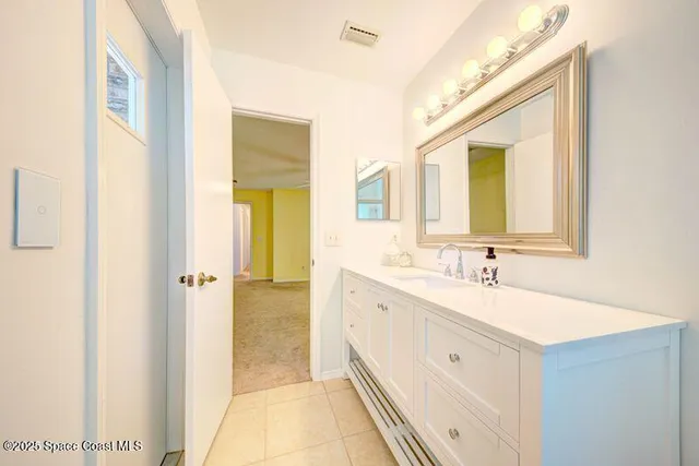 an empty room with a chandelier fan and windows