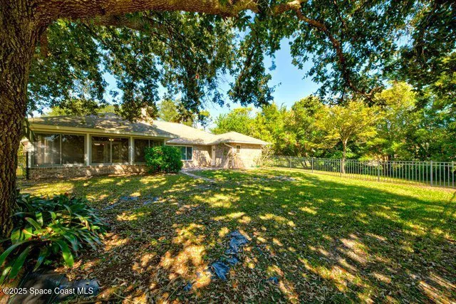 a view of a bedroom with wooden floor and a ceiling fan