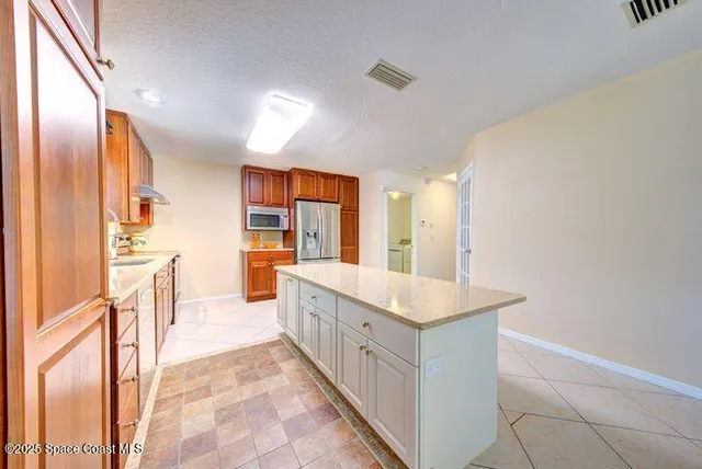 a kitchen with stainless steel appliances a sink and a refrigerator