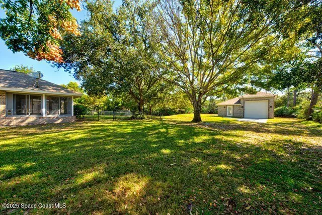 a front view of house with yard and trees in the background