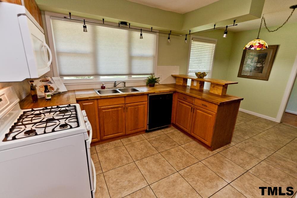 4305 Hopson Drive Raleigh, NC 27604 - Photo 4 of 14 Kitchen with tile, gas range, bar and natural light from large windows.