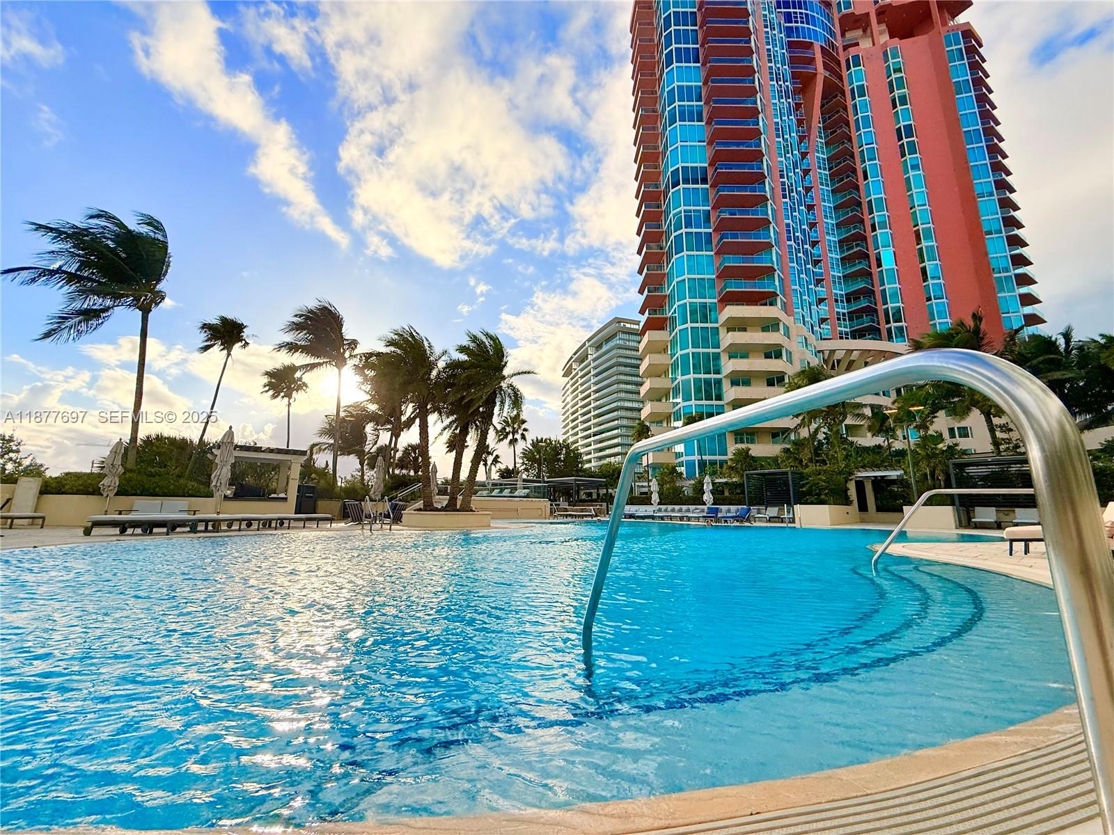 300 South Pointe Drive, Unit 2806 Miami Beach, FL 33139 - Photo 29 of 68 a view of a swimming pool with a bench and trees in the background