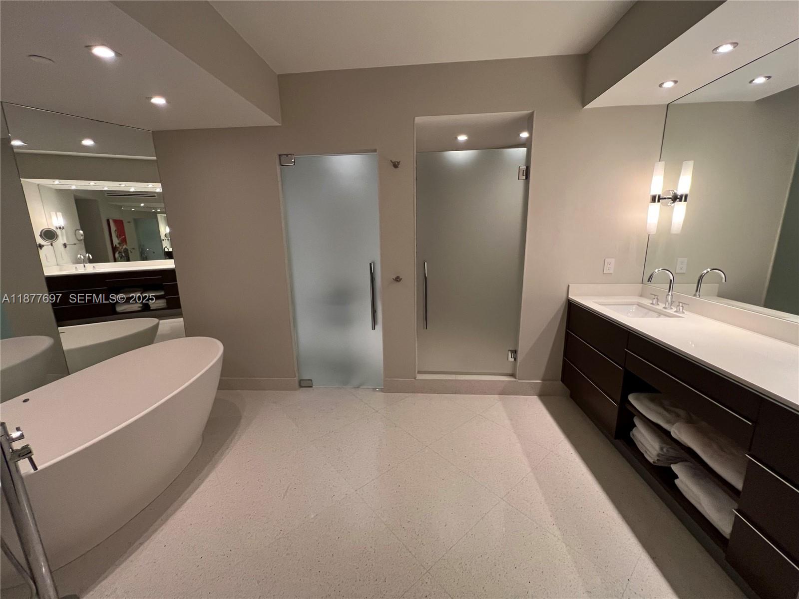 300 South Pointe Drive, Unit 2806 Miami Beach, FL 33139 - Photo 6 of 68 a bathroom with a double vanity sink a large mirror and shower