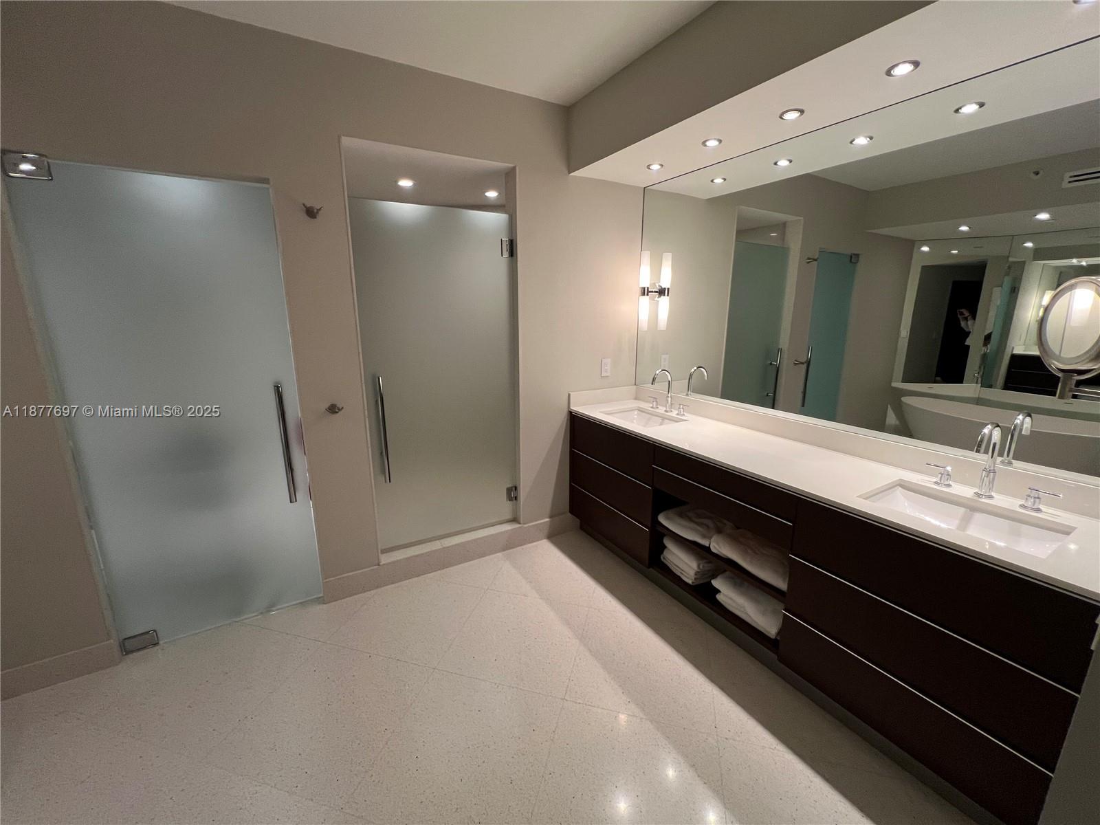 300 South Pointe Drive, Unit 2806 Miami Beach, FL 33139 - Photo 7 of 68 a bathroom with a double vanity sink a large mirror and shower