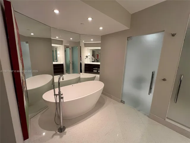 a large kitchen with a sink stainless steel appliances and a counter top space