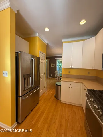 a kitchen with stainless steel appliances granite countertop a refrigerator a stove and a sink