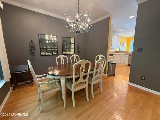 a view of a dining room with furniture wooden floor and chandelier