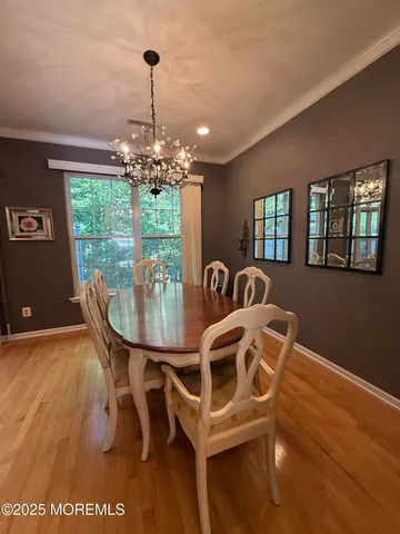 a view of a dining room with furniture a chandelier and wooden floor