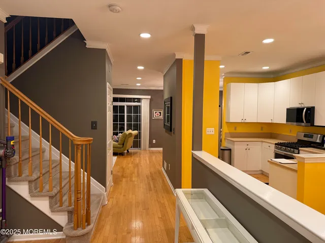 a view of a kitchen with kitchen island a large counter space wooden floor and stainless steel appliances