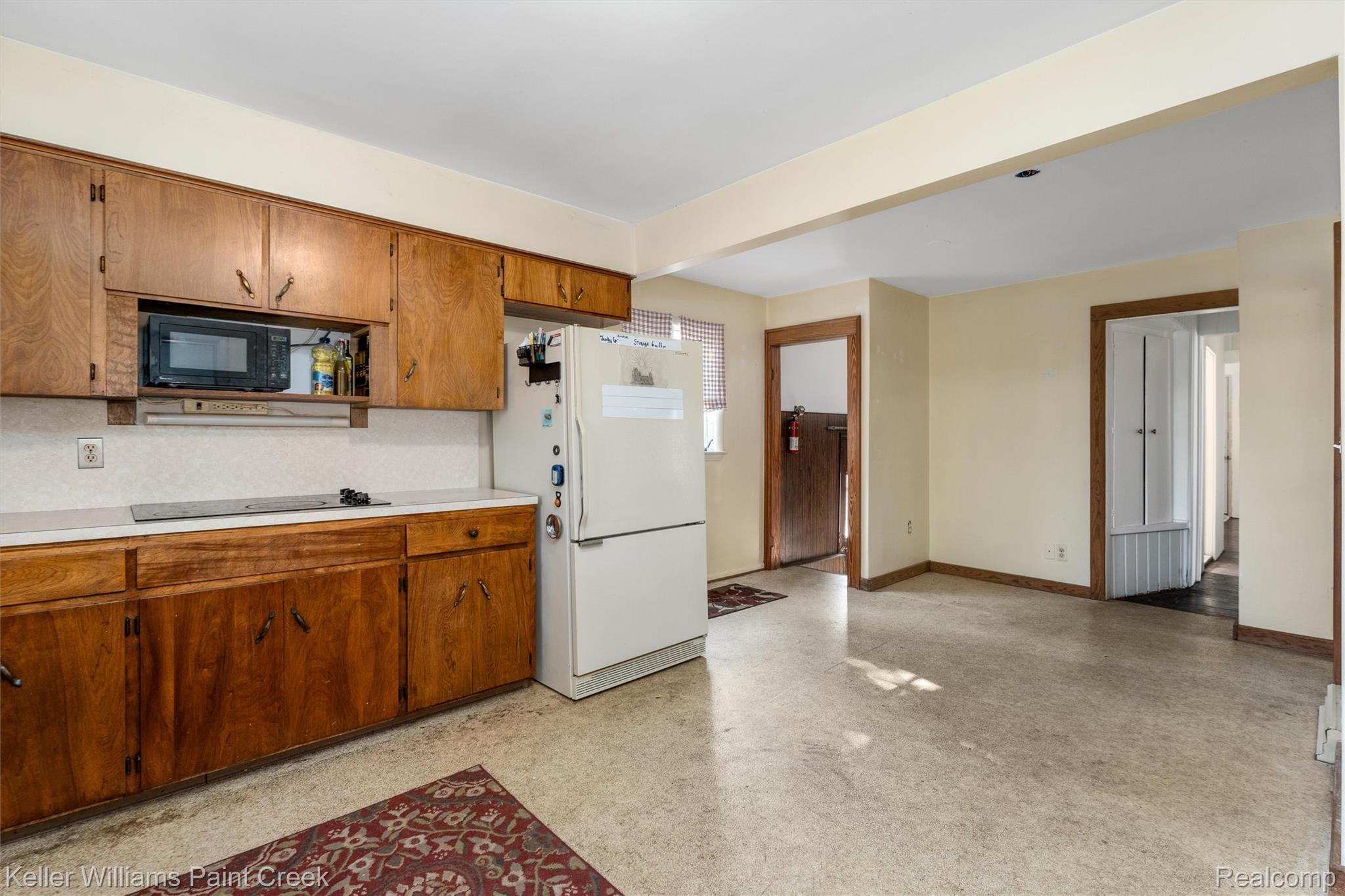 328 Ferndale Avenue Rochester, MI 48307 - Photo 30 of 54 Wood-finish cabinetry with black hardware, white countertop, white tile backsplash, integrated microwave, and neutral wall paint