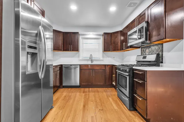 a kitchen with stainless steel appliances granite countertop a stove a sink and a refrigerator