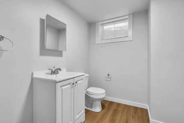 a bathroom with a toilet a sink and mirror