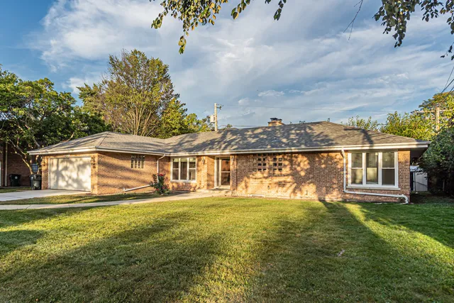 a view of house with yard and sitting area