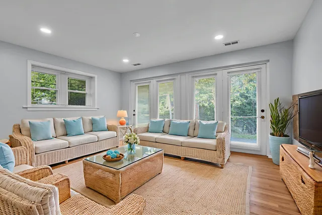 a living room with furniture a flat screen tv and a large window