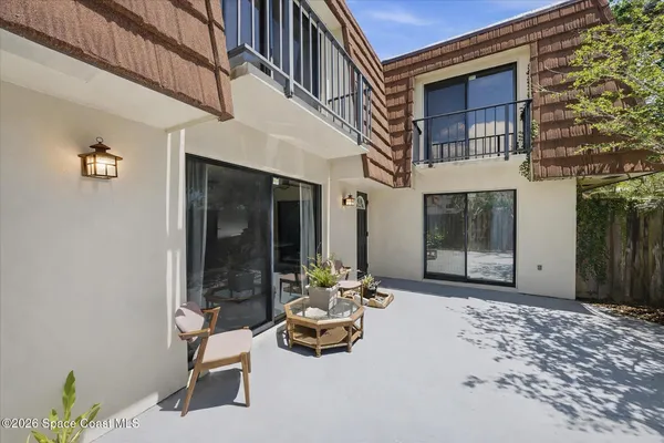 a building outdoor space with patio furniture and white walls