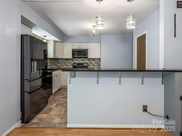 a kitchen with stainless steel appliances kitchen island granite countertop a refrigerator and a stove top oven