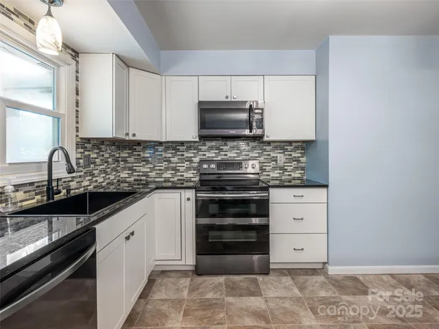 a kitchen with stainless steel appliances a stove sink and cabinets