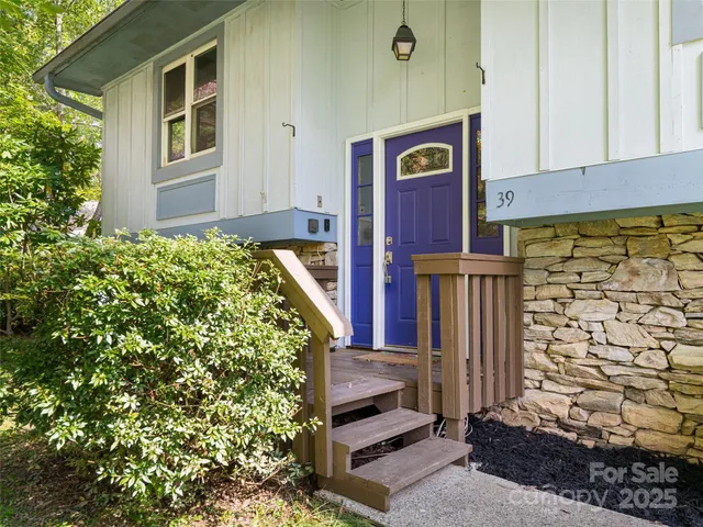 a front view of a house with a tree