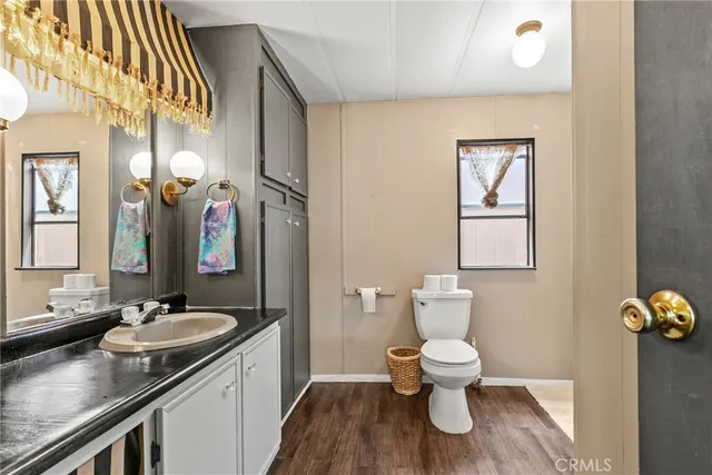 a bathroom with a granite countertop sink a toilet and a mirror