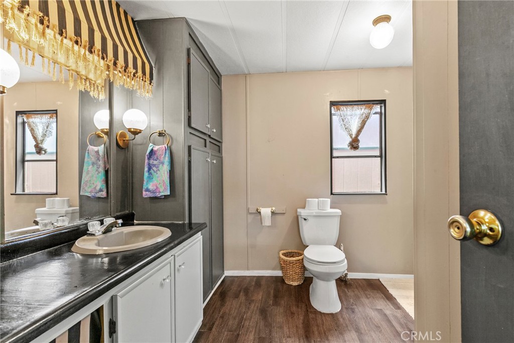 519 West Taylor Street, Unit 252 Santa Maria, CA 93458 - Photo 14 of 52 a bathroom with a granite countertop sink a toilet and a mirror